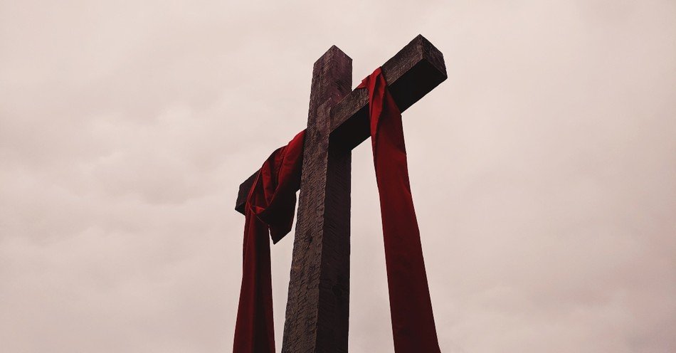 Red ribbons hanging from a cross
